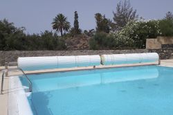 Una piscina con cubierta de lamas fijas
